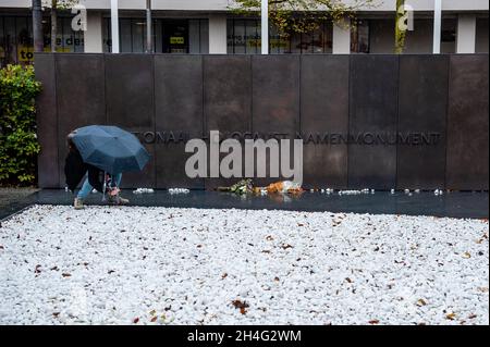 Amsterdam, pays-Bas, 02/11/2021, Une femme cueillant des pierres blanches pour mettre près des briques avec les noms des victimes comme hommage, au mémorial.soixante-dix ans après la Seconde Guerre mondiale, plus de 102,000 victimes de l'Holocauste ont enfin leur propre mémorial.Ce mémorial national est situé au coeur du quartier juif d'Amsterdam.Le mémorial se compose d'un labyrinthe de passages flanqués de murs de briques de deux mètres de haut qui transmettent le message «en mémoire de».Le nom de chaque victime de l'Holocauste est inscrit sur chacune des briques.La plupart des personnes visitant le mémorial, sont h Banque D'Images