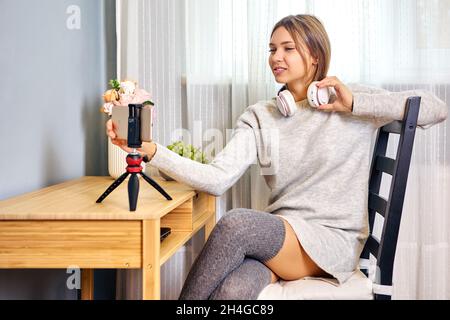 Le trépied de table avec support de téléphone est utilisé par une femme qui regarde la vidéo. Banque D'Images