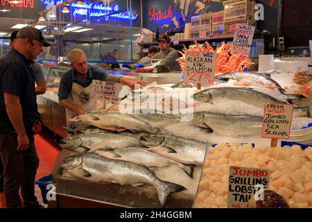 Fishmonger vendant des poissons frais et d'autres fruits de mer aux clients de Pike place Market.Seattle.Washington.USA Banque D'Images