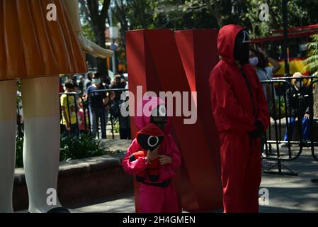 Mexico, Mexique.Le 2 novembre 2021, les visiteurs prennent des photos devant une réplique d'une poupée animée de la série Netflix 'Squid Game' a été installée sur la place principale de Coyoacan pour inviter les fans et les enfants à jouer au jeu populaire pour enfants réalisé par une émission de télévision populaire.Le 2 novembre 2021 à Mexico, Mexique.(Photo de Carlos Tischler/Eyepix Group) Banque D'Images