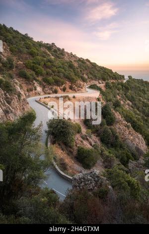 La route D824 s'enroule le long de la côte de Piana vers Capu Rossu sur la côte ouest de la Corse au lever du soleil Banque D'Images