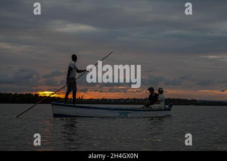 Un pêcheur local emmène les touristes sur une promenade en canoë à la crique de Mida pour observer le coucher du soleil qui fait partie du parc national marin et réserve de Watamu.le parc national marin et réserve de Watamu est situé dans la partie côtière du Kenya et a été établi en 1968 comme l'un des premiers du Kenyaparcs marins.C'est une zone protégée qui est également reconnue internationalement comme réserve de biosphère de l'UNESCO.La région est désignée comme un site d'excellence naturelle et devrait démontrer comment les populations locales et l'environnement peuvent coexister grâce à une gestion prudente de nos ressources marines naturelles et de nos ressources humaines.La Marine Banque D'Images