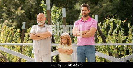 Bannière de la famille de génération masculine avec trois générations différentes âge grand-père père et fils dans le jardin d'été. Banque D'Images