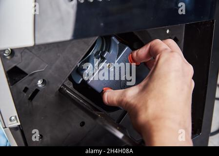 Nettoyage automatique de la machine à café.La femme insère le mécanisme dans la machine à café.Entretien des appareils ménagers Banque D'Images