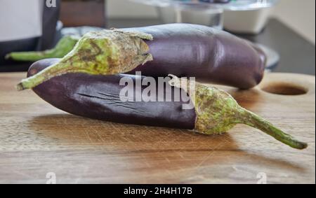 Les aubergines japonaises sont situées sur des planches de bois dans la cuisine. Banque D'Images