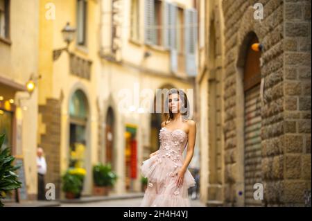 Une mariée dans une robe de mariage rose marche à Florence, Italie. Banque D'Images