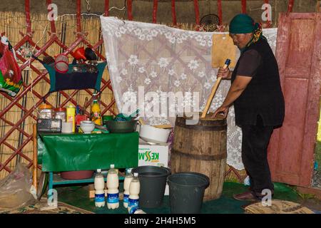 Femme kirghize mélangeant des kumis pendant le processus de fermentation, lac Song Kol, province de Naryn, Kirghizistan, Asie centrale Banque D'Images