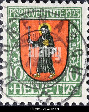 Suisse - Circa 1923: Timbre-poste imprimé en Suisse montrant un blason rouge mit Saint Fridolinus, missionnaire irlandais du c suisse Banque D'Images