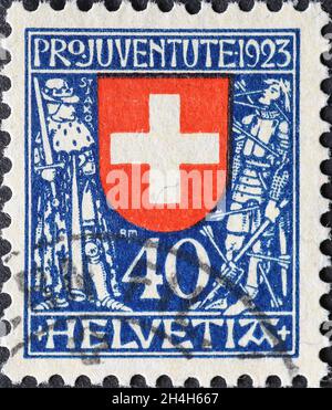 Suisse - Circa 1923: Timbre-poste imprimé en Suisse montrant le blason fédéral de la Suisse avec des porte-boucliers de guerriers Banque D'Images