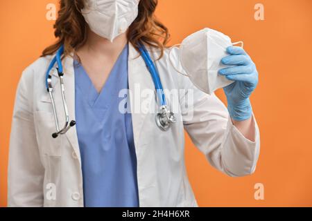 Une infirmière tient un masque médical n95 ffp2 dans sa main. Le concept de protection des médecins pendant l'épidémie du coronavirus. Banque D'Images