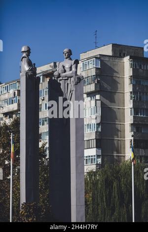 Bucarest, Roumanie - 27 octobre 2021 : statue de style communiste/soviétique représentant des soldats avec des blocs d'appartements en arrière-plan. Banque D'Images
