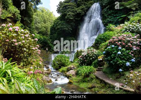 Femme touriste regardant les cascades d'une cascade de Ribeira dos Caldeirões sur l'île de Sao Miguel aux Açores, Portugal Banque D'Images