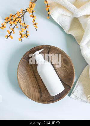 Bouteille en plastique blanc avec maquette de pompe, utilisée pour le savon liquide, le shampooing et la lotion sur le plateau en bois sur fond bleu.Vue de dessus Banque D'Images