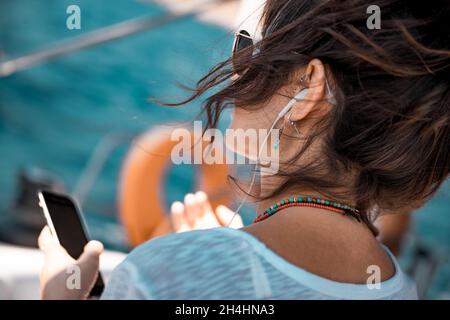 Traveler Girl avec plaisir écouter de la musique sur le Voilier.Apprécier Nice Melody.Voyage d'été de luxe en Grèce.Joyeuses fêtes sur le yacht. Banque D'Images