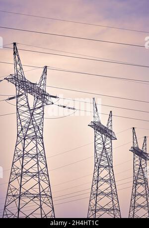 Vue des tours de transmission haute tension contre le ciel, couleur appliquée. Banque D'Images