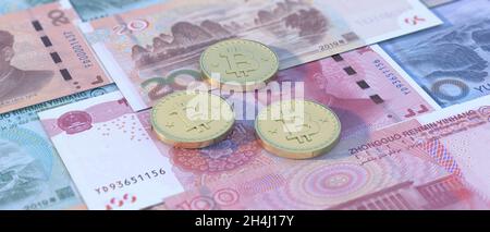Yuan et crypto-monnaie.Les bitcoins sont empilés sur le fond des billets de billets en renminbi chinois.Argent virtuel contre les billets papier, l'investissement, l'échange.3d il Banque D'Images