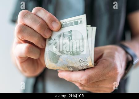 Homme détenant des billets en papier Dinar en monnaie serbe, attention sélective Banque D'Images