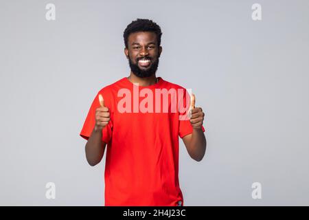 Un homme afro-américain heureux et enthousiaste montrant un bon client recommandant un service, isolé sur fond gris Banque D'Images