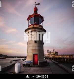 Phare en granit dominant de Ramsgate situé à l'extrémité du mur de défense maritime du port et entrée dans le port historique de Royal Harbour capturé au coucher du soleil. Banque D'Images