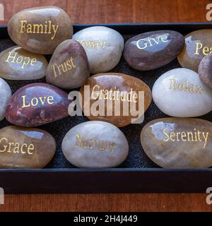 Pierres motivationnelles inspirantes avec des écrits.Sérénité, gratitude, passion, amour sur fond de table rouge Banque D'Images