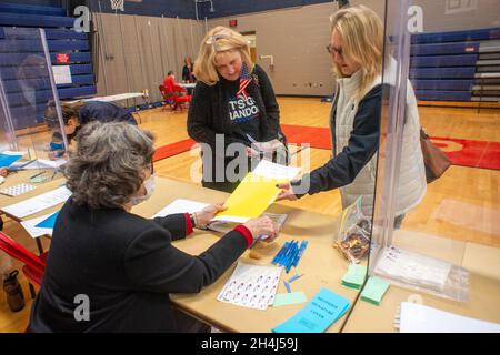 Buckingham, États-Unis.02 novembre 2021.De gauche à droite, Pat Thureson, de Lahaska, remet des formulaires d'électeur à Donna Mortimer et Jennifer Mortimer, toutes deux de Buckingham, tout en votant au bureau de vote le mardi 02 novembre 2021 à la Central Bucks East High School de Buckingham, en Pennsylvanie.( Credit: William Thomas Cain/Alamy Live News Banque D'Images