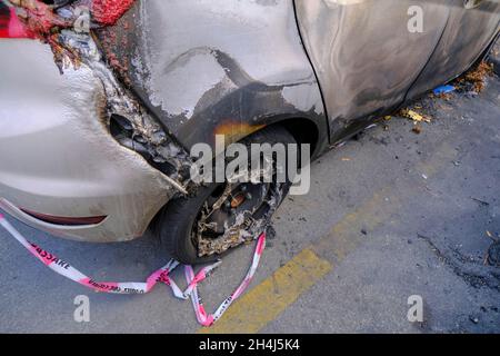 Roue cassée et brûlée du gros plan de la voiture.Émeute, protestation civile, hooliganisme, criminel dans la ville. Banque D'Images