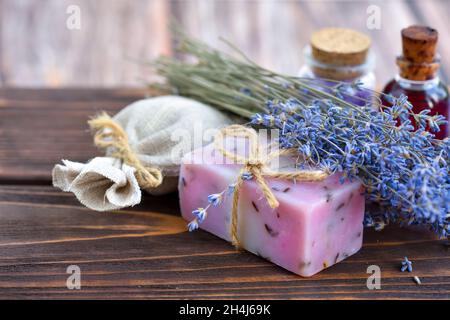 Produits spa lavande sur table en bois.Produits de soin du corps à la lavande : savon, huile, sel et fleurs de lavande séchées.Mise au point sélective. Banque D'Images