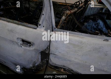 Porte de voiture brûlée dans la rue en gros plan.Émeute, protestation civile, hooliganisme, criminel dans la ville.Explosion, incendie.Concept d'assurance automobile Banque D'Images