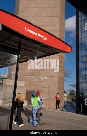 Les membres du public marchent sous l'architecture des années quatre-vingt numéro 1 London Bridge, le 2 septembre 2021, à Londres, Angleterre.One London Bridge (1986) a été conçu par le John S. Bonnington Partnership sur le côté sud du London Bridge à Londres.Il s'agit d'un espace de bureau de 13 étages composé de sections revêtues de granit rose et d'acier inoxydable.L'avant distinctif du bâtiment est découpé à l'angle avec une lucarne découpée en haut. Banque D'Images