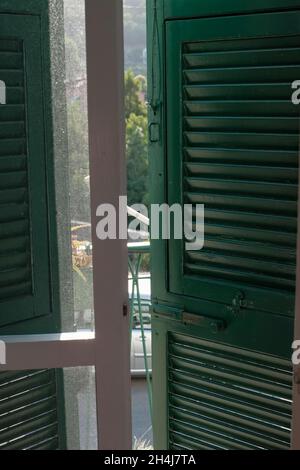 portes blanches avec stores verts de la terrasse sur une rue ensoleillée.Intérieur de la maison.Terrasse intérieure Banque D'Images