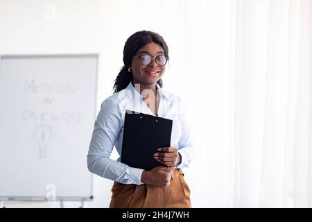 Concept d'éducation psychologique.Jeune entraîneur d'affaires noir joyeux menant une formation personnelle de croissance au bureau Banque D'Images