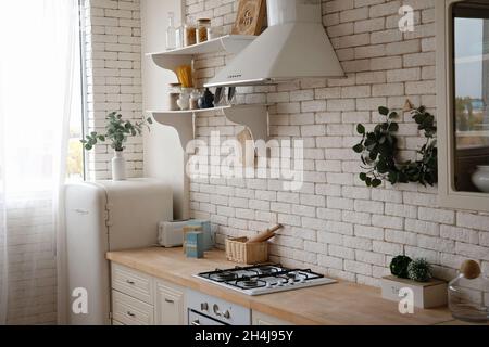 Cuisine scandinave moderne et élégante, en bois clair et blanc, avec accessoires de cuisine.Cuisine blanche lumineuse avec articles ménagers . Banque D'Images