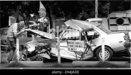 Voiture après un accident majeur où une personne est morte, en étant regardés - garés à l'école secondaire locale de Californie avec un clown derrière elle - ne soyez pas un!!! Banque D'Images