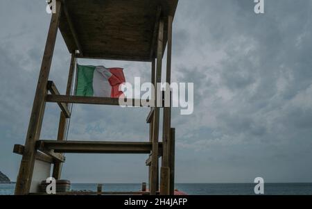 Tour des sauveteurs sur la plage avec drapeau italien sur le ciel bleu.Concept de sécurité sur la plage Banque D'Images