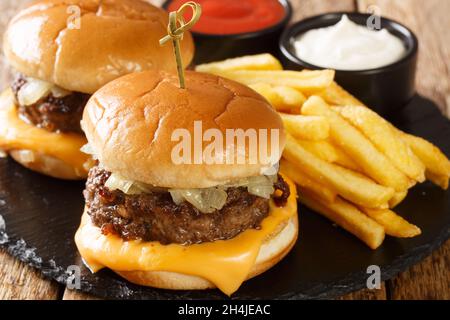 Burgers au beurre composés d'une patty hamburger au beurre poêlé, d'une tranche de fromage, d'oignons cuits au beurre et d'un petit pain moelleux recouvert de beurre en gros plan Banque D'Images