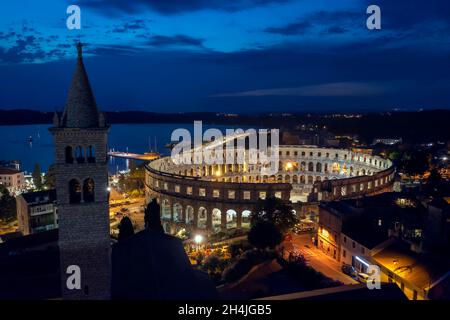 Vue aérienne de nuit de l'aphithéâtre Pula, sur le clocher gauche de l'église Saint-Antun, Istrie, Croatie Banque D'Images