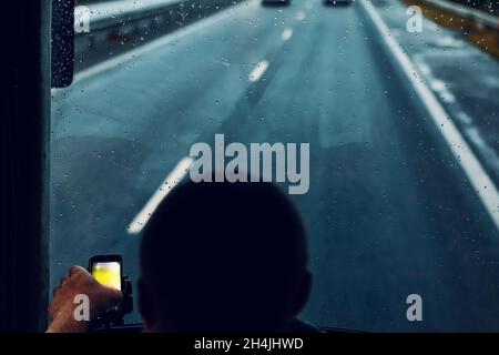 Conduite dans la nuit des pluies.Vue arrière conducteur .Gouttes de pluie sur le pare-brise .Vue sur la route depuis la cabine conducteur Banque D'Images