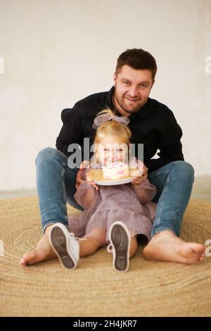 Le père et le dauther célèbrent l'anniversaire de leur petite fille.Fête d'anniversaire en robes avec gâteau. Banque D'Images