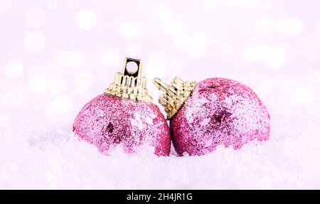 Carte postale d'arrière-plan de Noël aux couleurs roses.Boules de Noël vintage sur la neige sur fond de bokeh.Bannière.Copier l'espace Banque D'Images