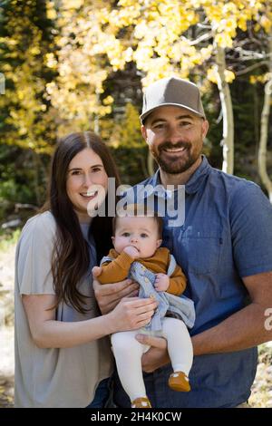 Portrait d'un couple heureux debout dans la forêt avec leur petite fille, Californie, Etats-Unis Banque D'Images