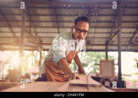 Menuisiers utilisant une scie circulaire dans son atelier, Thaïlande Banque D'Images