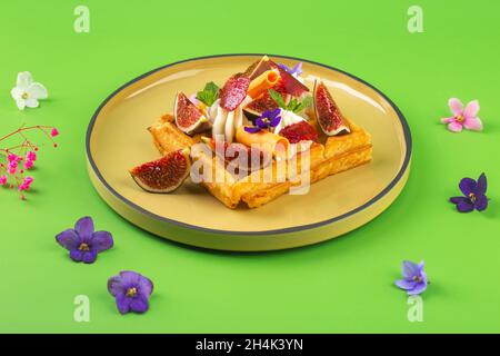 Gaufres belges avec figues crème, fleurs et baies Banque D'Images