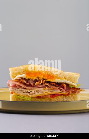 Sandwich petit déjeuner avec œufs, bacon et légumes sur fond gris Banque D'Images