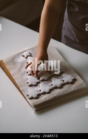 Arbre de Noël fait de biscuits au pain d'épice arrosé de sucre en poudre sur une planche de bois Banque D'Images