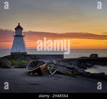 Coucher de soleil avec bateau à bord près du phare de Vigra, Norvège Banque D'Images