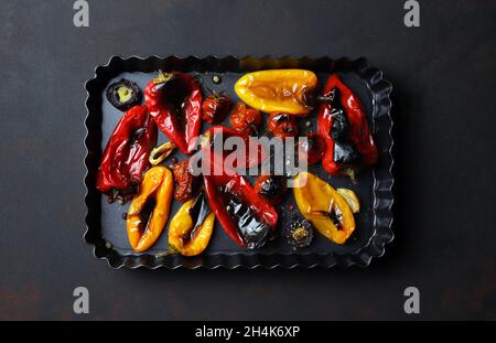Poivrons rouges et jaunes grillés sur plaque de cuisson sur fond sombre.Directement au-dessus.Aliments pour légumes. Banque D'Images