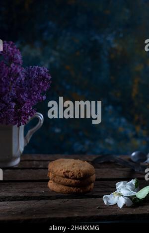 les biscuits continuent de vivre dans un style rustique sur un fond abstrait, avec des fleurs printanières. Banque D'Images