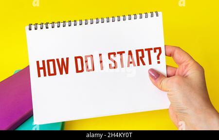 Comment commencer , le texte est écrit sur papier tenu par une main féminine sur fond jaune.Concept d'entreprise et de vie motivationnelle Banque D'Images