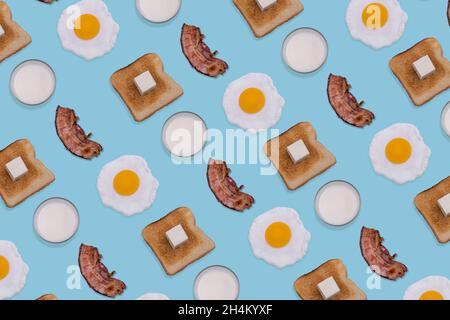 Motif composé d'œufs frits, de tranches de bacon croustillant, de pain grillé et de verres de lait sur fond bleu pastel.Petit déjeuner minimal et créatif Banque D'Images