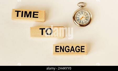 Il est temps d'engager du texte sur des cubes sur un fond blanc, une horloge se trouve à côté de Banque D'Images